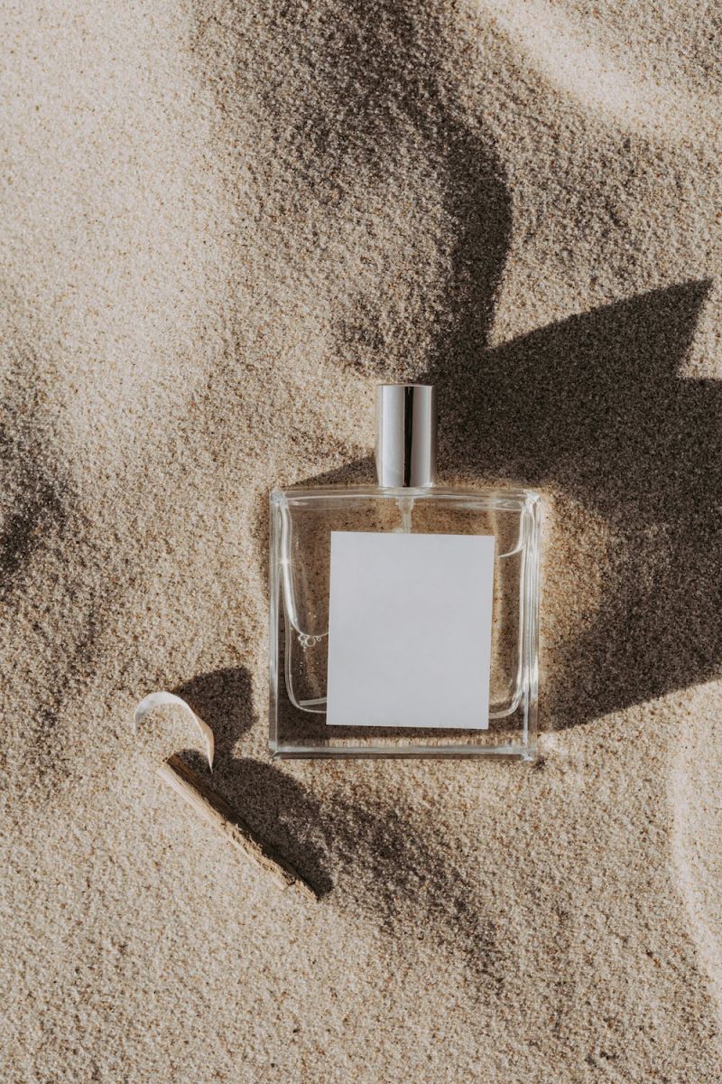 perfume filmado en la playa sobre un fondo de arena fina