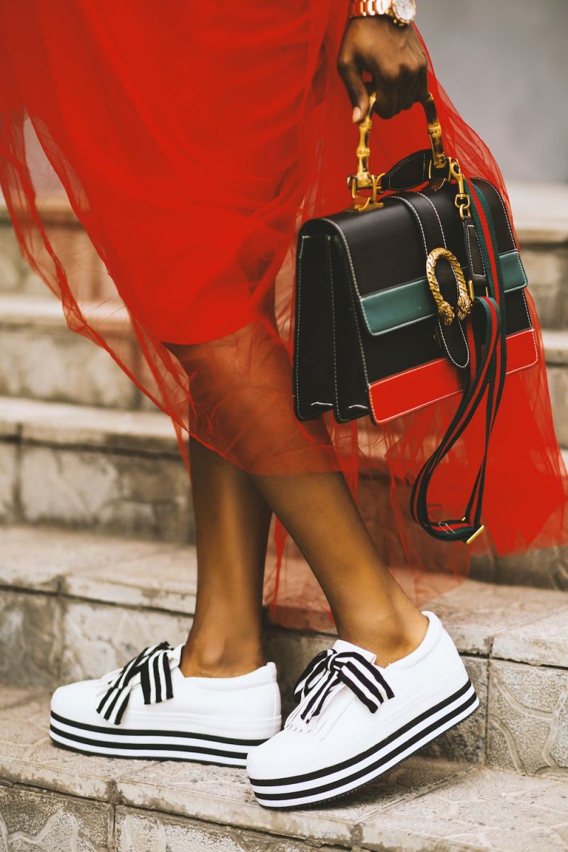 zapatillas blancas sobre vestido negro a rayas y rojo