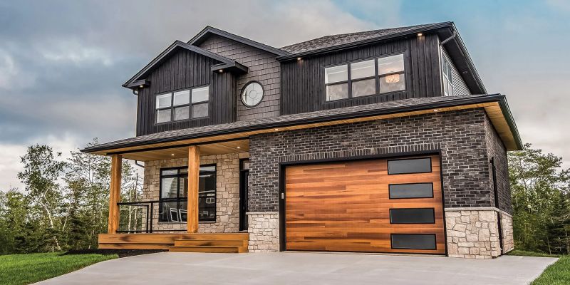 gran casa de piedra con garaje de madera y puertas de entrada